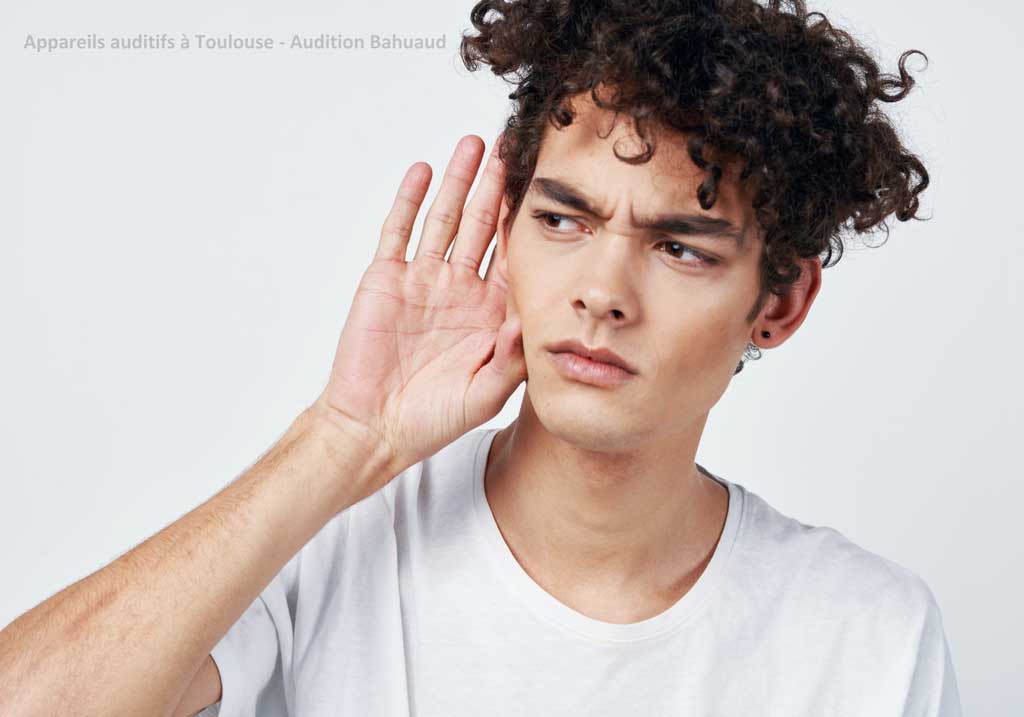 homme portant une main à son oreille