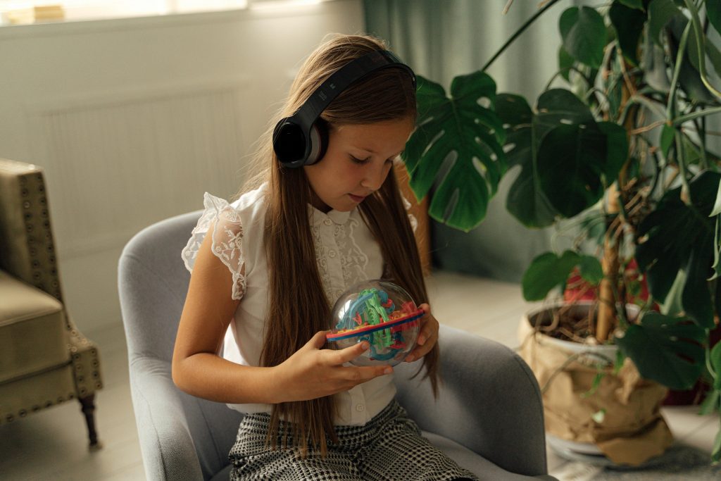 enfant jouant avec un jouet et portant un casque audio, 