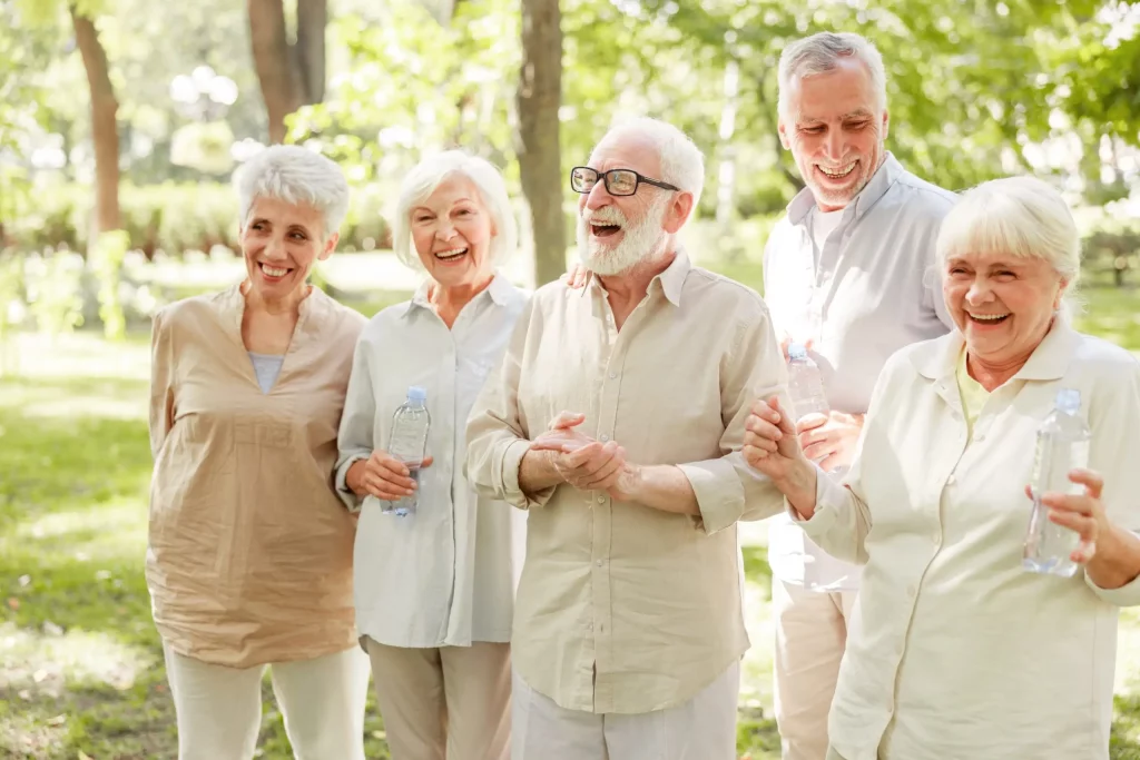 Groupe de seniors échangeant et riant ensemble lors d’une activité en plein air